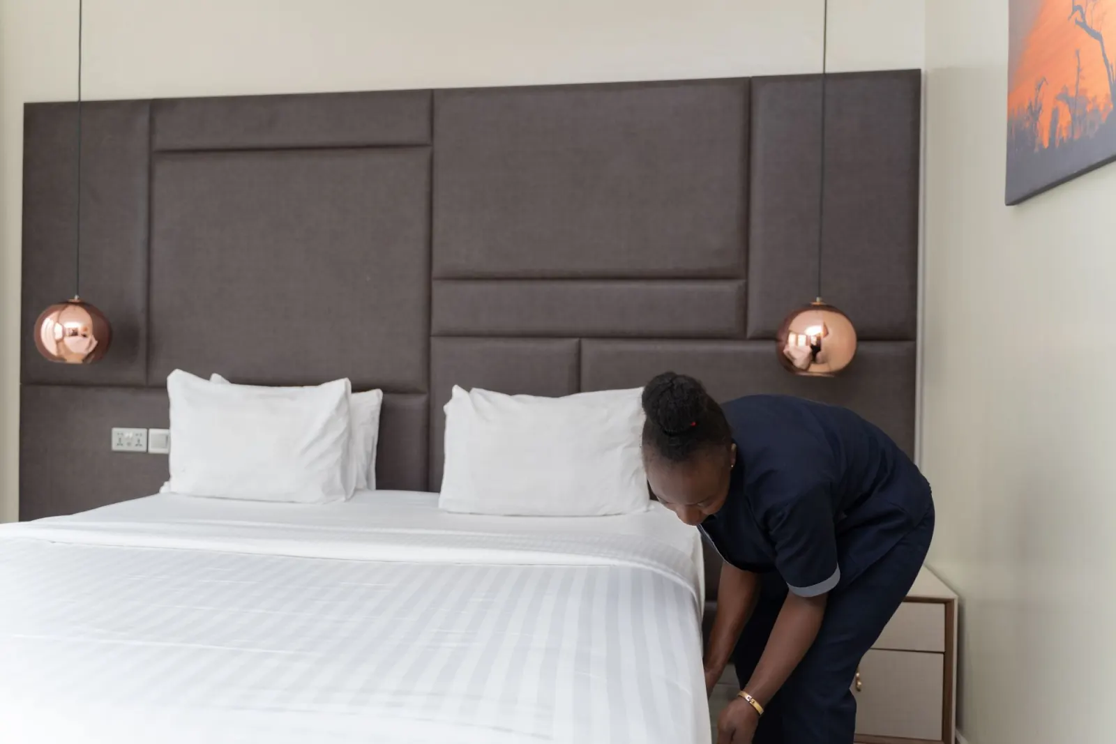 Un agent d'entretien prépare le lit d'une chambre meublée
